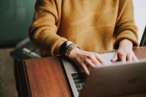 Person using a laptop during an online therapy session