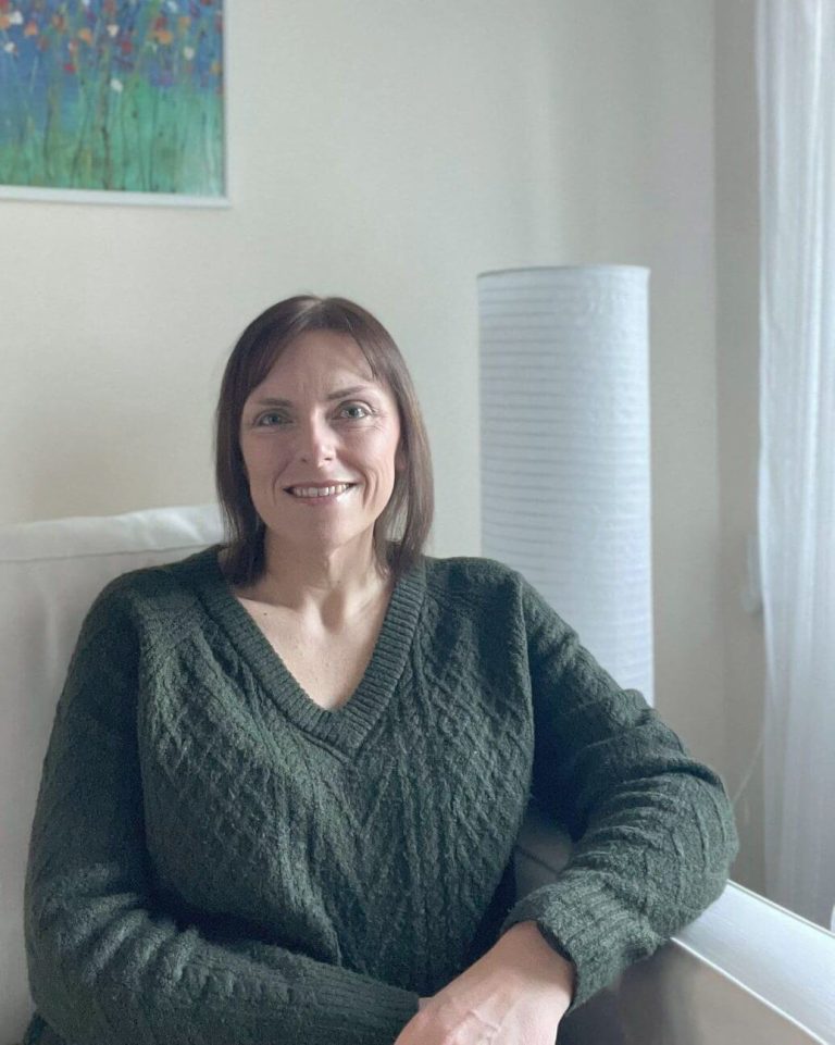 Sarah Lucas, counsellor in Exeter, sitting in her counselling room"