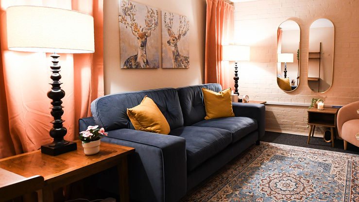 Navy sofa and warm lighting in therapy room at Sarah Lucas Counselling, Exeter